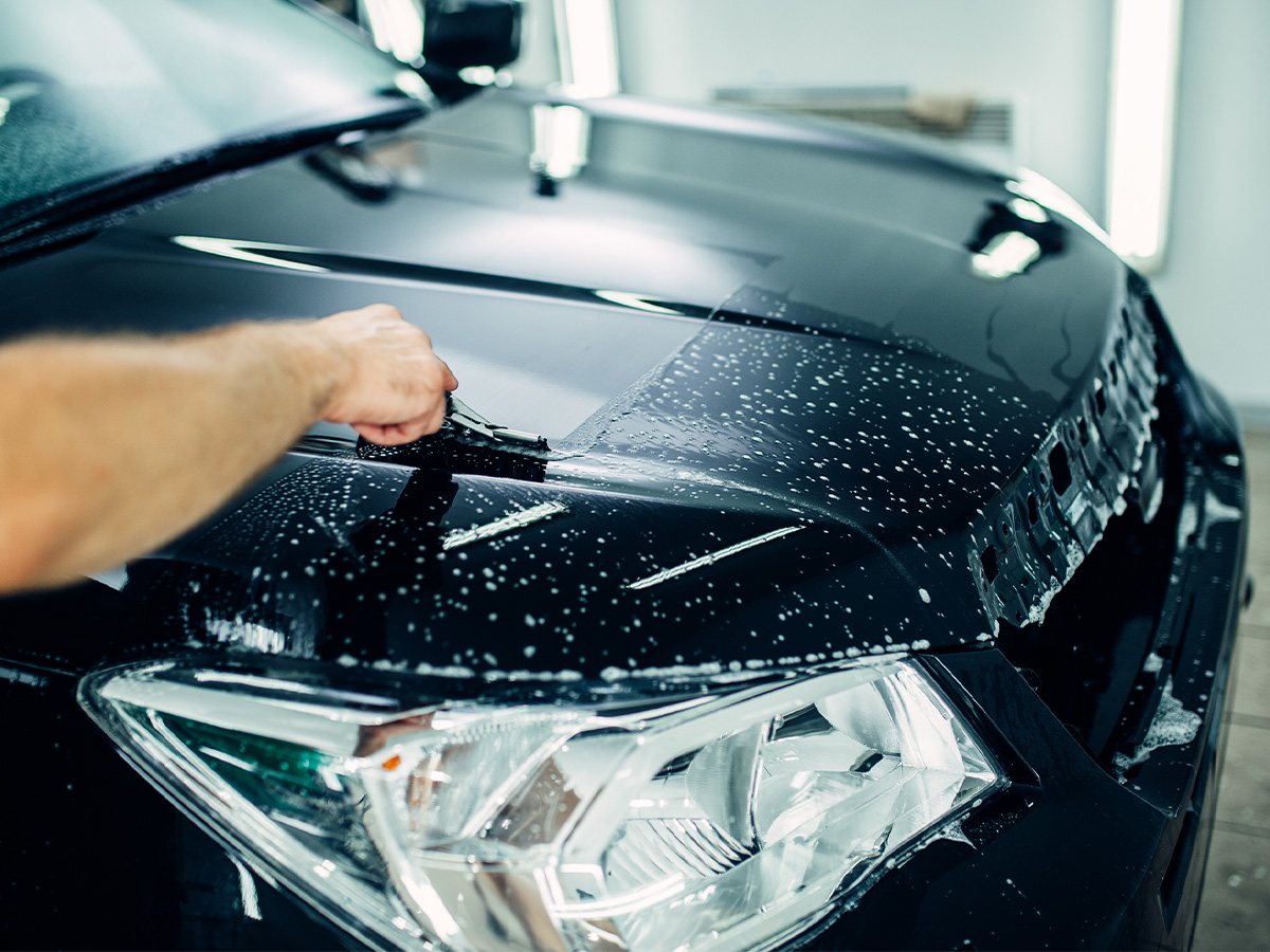 Specialist prepares car for protect against chips and scratches.