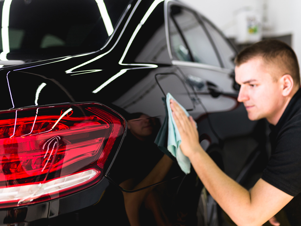 A man cleaning car with microfiber cloth